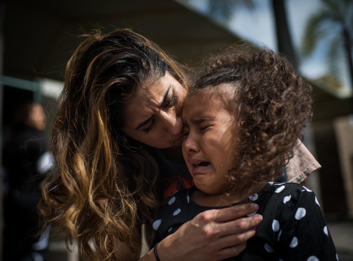 Natalie Garcia tries to console her daughter Marley after a visit with Garcia's father at the Theo Lacy Detention Facility in Orange. (Gabriel S. Scarlett / Los Angeles Times)