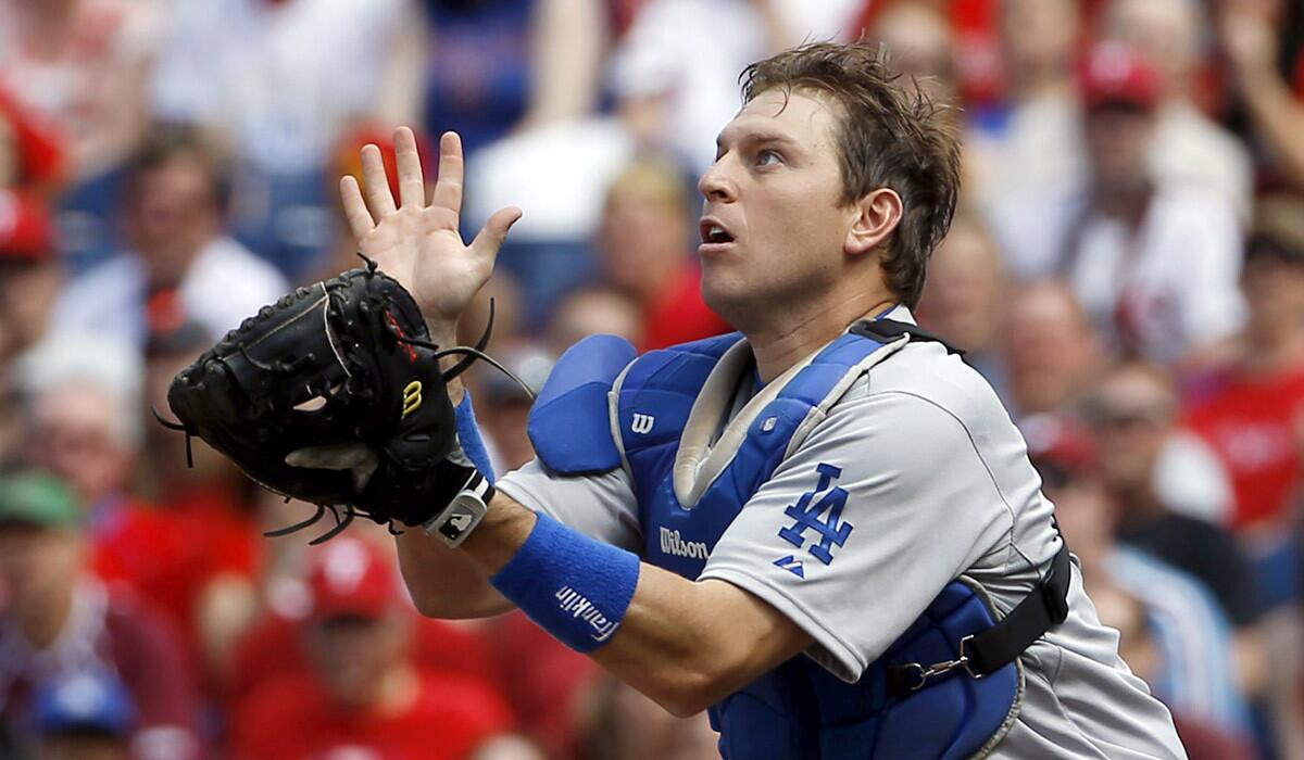 Dodgers catcher A.J. Ellis chases a pop fly during a game against the Phillies on Saturday in Philadelphia.