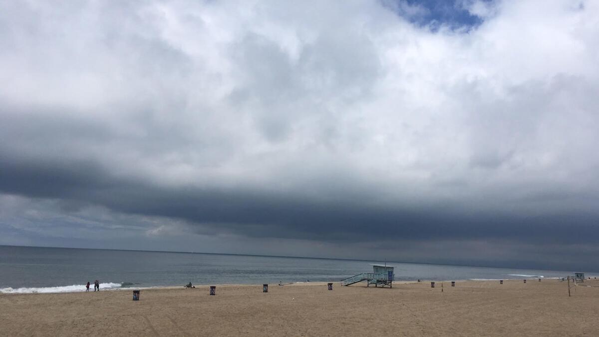 Storm clouds hang low over Manhattan Beach as an unusual late-season weather system brought rain and below-normal temperatures to the Los Angeles region.