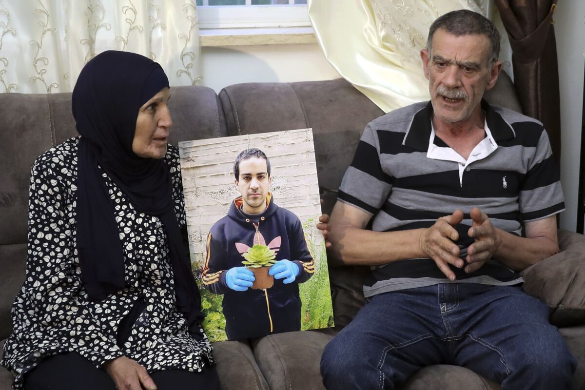 Parents of Eyah Hallaq, an autistic Palestinian man who was fatally shot by Israeli police, Khiri and mother Rana, talk during an interview In Jerusalem, Wednesday, June 3, 2020. The family says it is hopeful the officers will be prosecuted after finally confirming the existence of security-camera footage of the incident.(AP Photo/Mahmoud Illean)