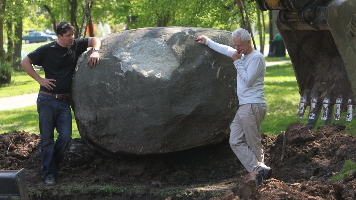 British artist Andy Goldsworthy, right, works on his art installation "Rising Stone" in 2013 in Buffalo, N.Y. A documentary about him will be screened Feb. 1 as part of Laguna Beach's First Friday Flicks program.