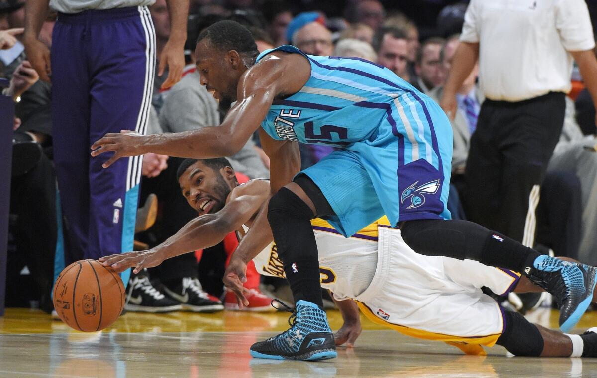 Lakers guard Ronnie Price tries to beat Hornets guard Kemba Walker to a loose ball in the first half.