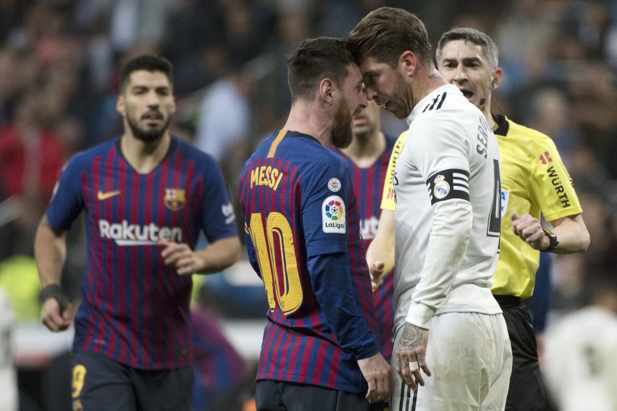 Barcelona's Argentinian forward Lionel Messi (2L) argues with Real Madrid's Spanish defender Sergio Ramos during the Spanish league football match between Real Madrid CF and FC Barcelona at the Santiago Bernabeu stadium in Madrid on March 2, 2019.