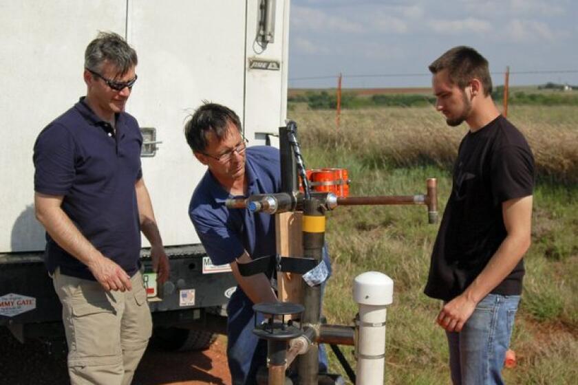 Storm chaser Tim Samaras, center, working in the field with Carl Young, left, and his son Paul Samaras.