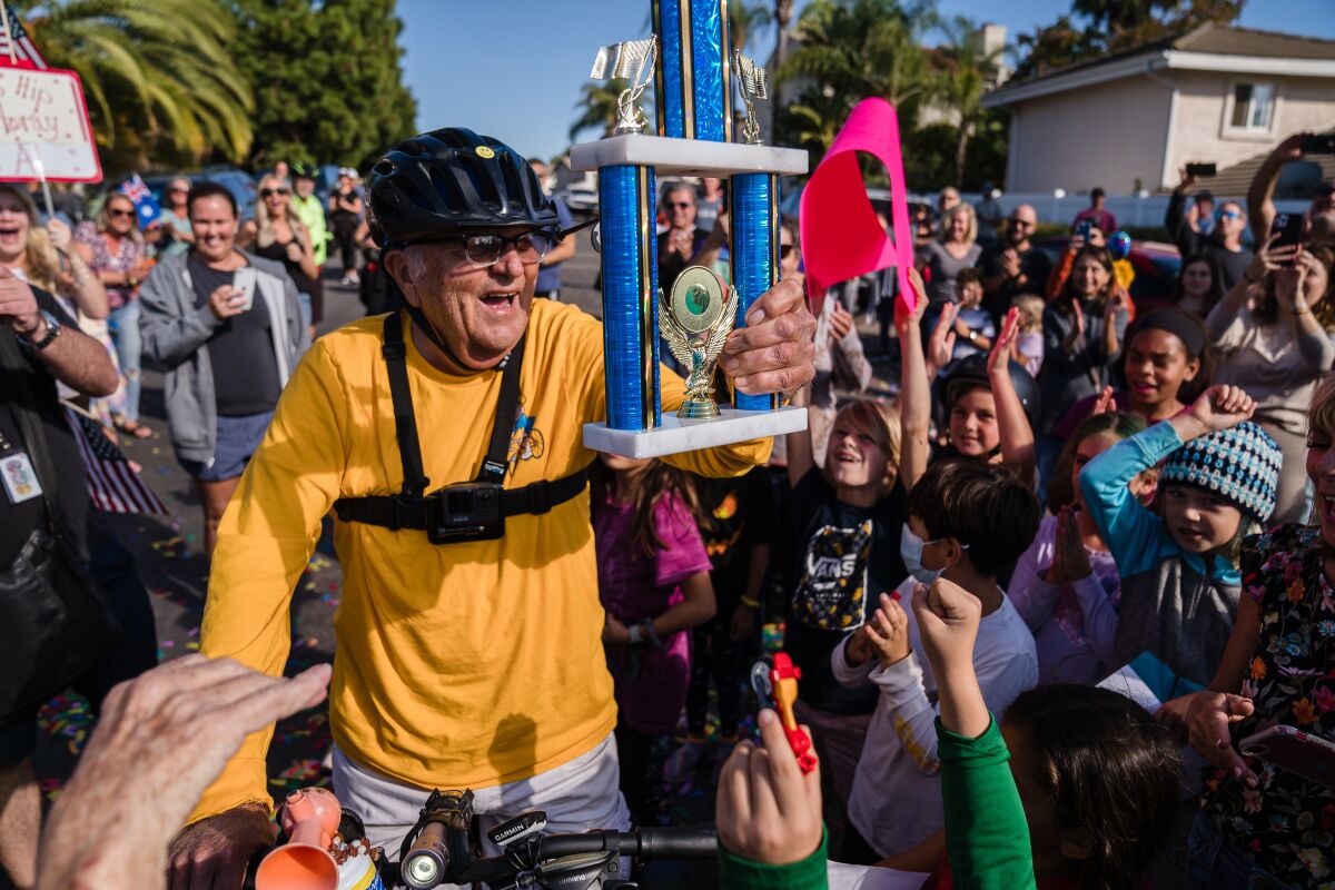 Al Merritt, 83, holds a trophy near his Carlsbad home after cycling the equivalent of the circumference of the Earth.  