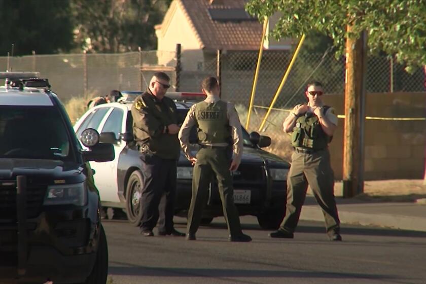 Police cars crowd a Rosamond, Calif., street where deputies fatally shot a man.(KTLA)
