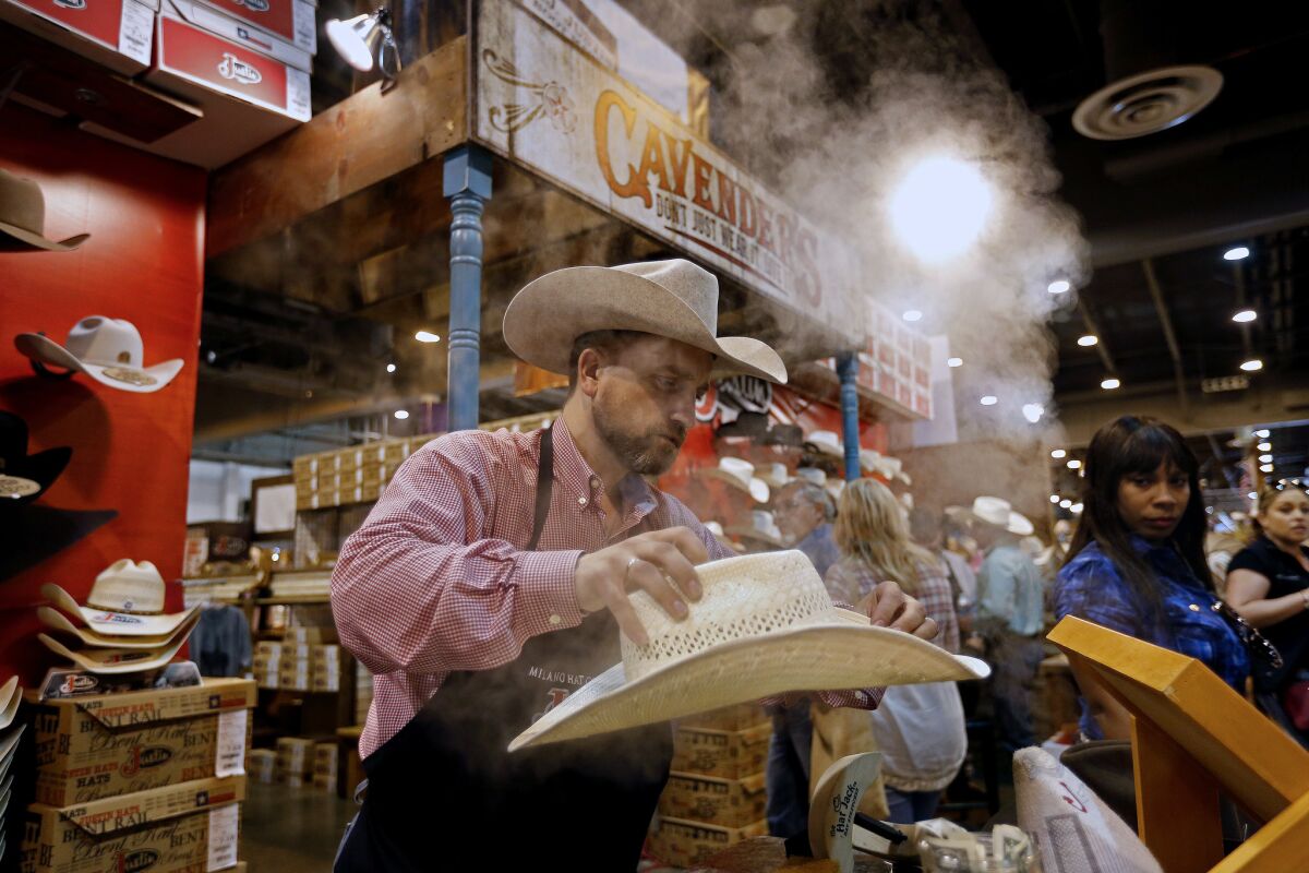Bryan Scott adjusts the shape of a cowboy hat at the Houston Livestock Show and Rodeo at NRG Park in Houston