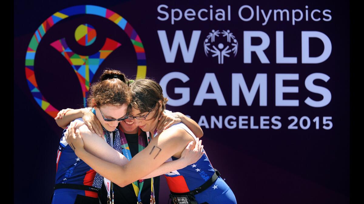 USA medal winners Amy Noctor, left, and Courtney Dreyfus, right hug gold medal winner Florencia Barranque after the triathlon competition of the Special Olympics in Long Beach on Sunday.