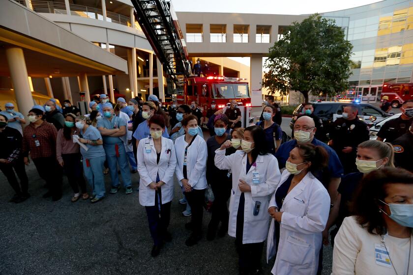 GLENDALE, CALIF. - APR. 14, 2020. Healthcare workers, cops and firefighters gather for a morale-boosting tribute to the fight against the coronavirus pandemic at Glendale Adventist Hospital on Tuesday, Apr. 14, 2020. Glendale cops and firefighters clapped, shined their vehicle lights and sounded sirens as hospital workers were showered with gratitude for their efforts to battle the contagious and deadly disease. (Luis Sinco/Los Angeles Times)