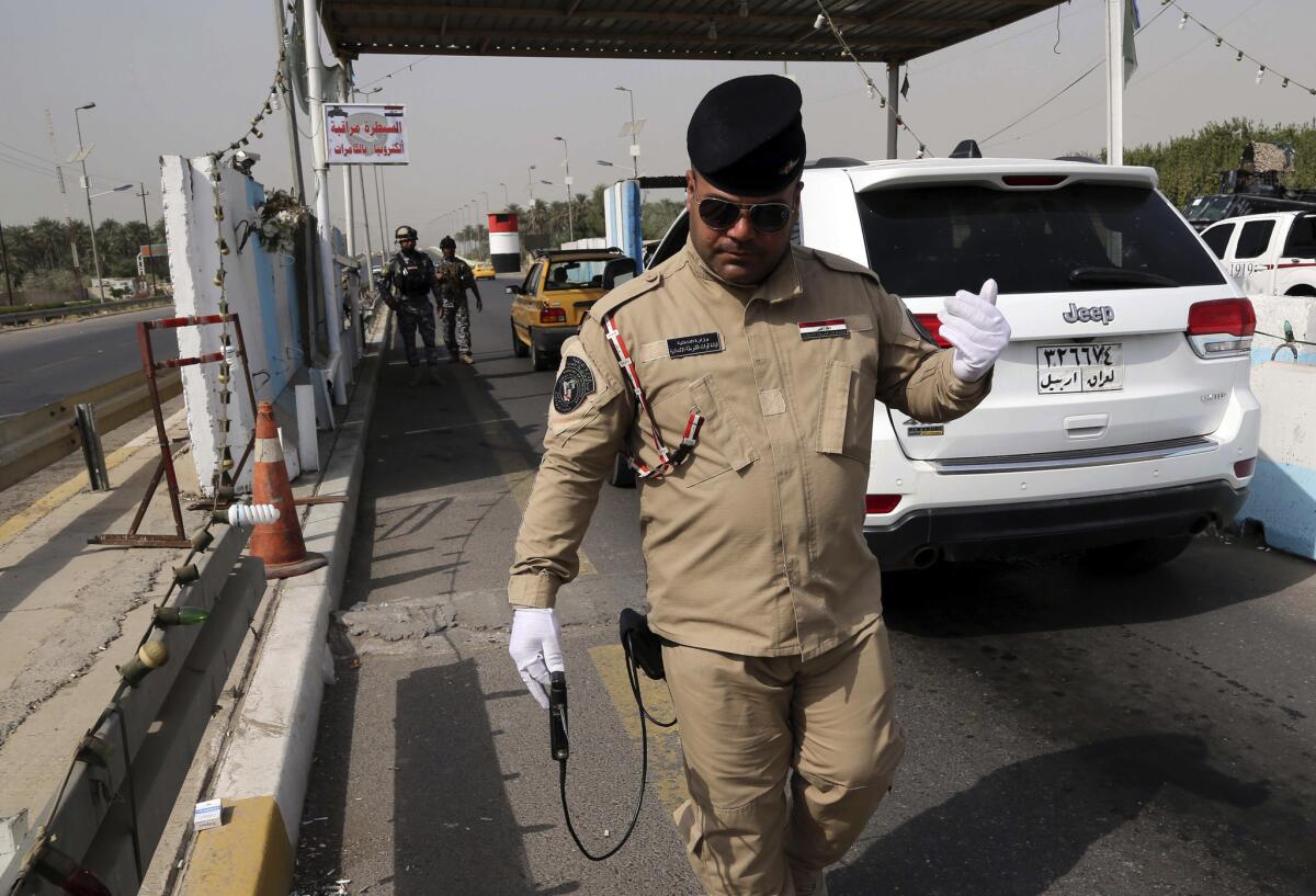 An Iraqi federal policeman uses a hand-held device that is supposed to detect bombs at a checkpoint in Baghdad, Iraq, on Saturday. That same day three bombs exploded in the city.
