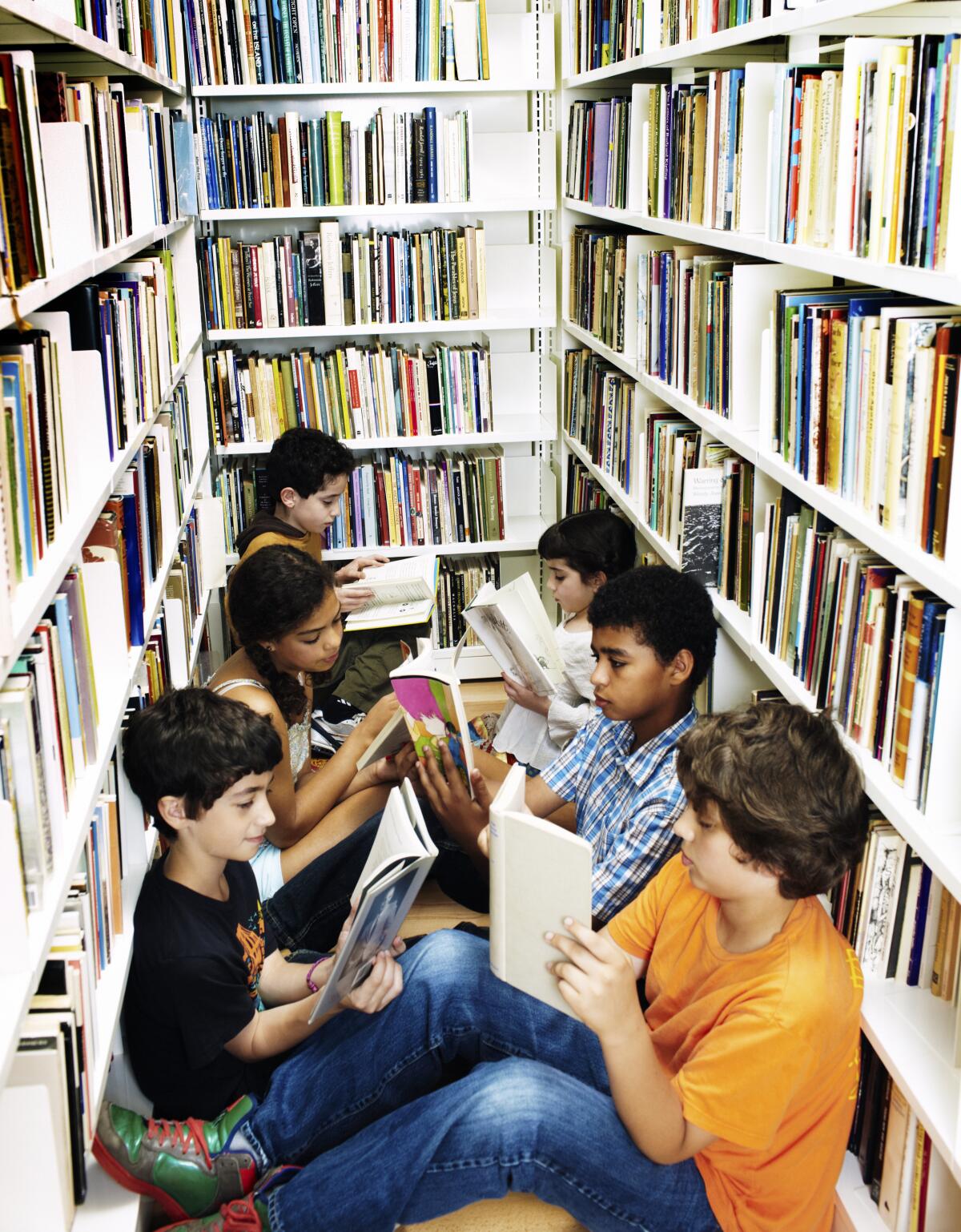 children reading on floor in library stack
