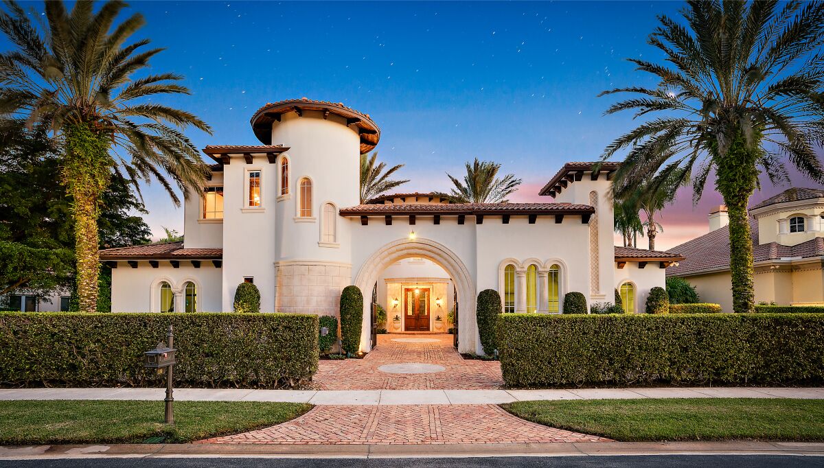 The two-story home enjoys golf course views from a second-story balcony and a covered loggia.