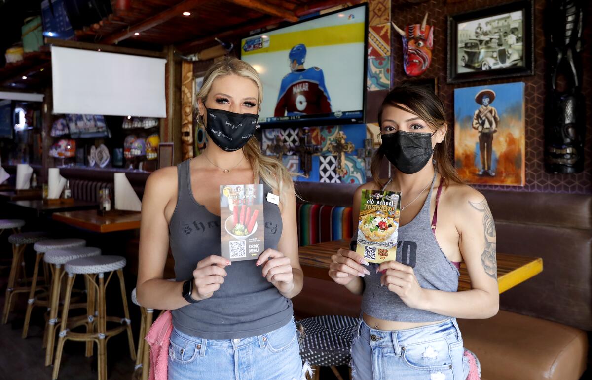 Manager Samantha Kinsella and server Ebony Gallegos, from left, at Baja Sharkeez in downtown Huntington Beach on Thursday. 
