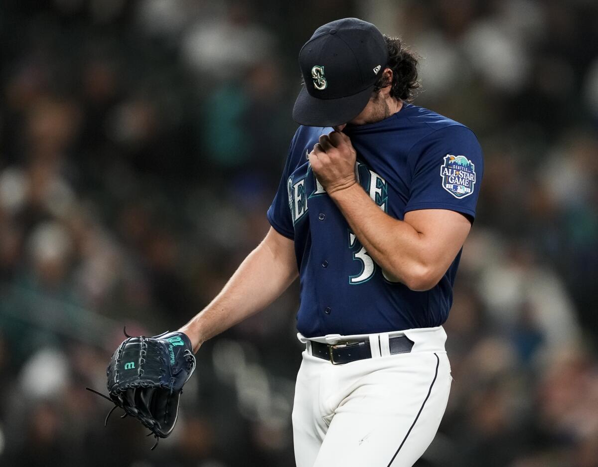 Seattle Mariners starting pitcher Robbie Ray wipes his face as he walks off of the field after being removed during the fourth inning of the team's baseball game against the Cleveland Guardians on Friday, March 31, 2023, in Seattle. (AP Photo/Lindsey Wasson)
