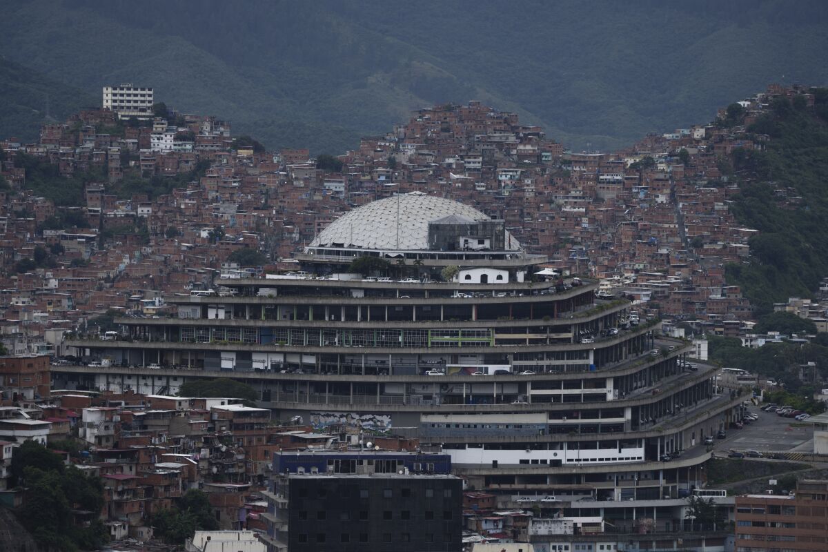 FILE - Venezuela's National Intelligence Service (SEBIN) headquarters, known as El Helicoide, stands in front of La Cota 905 neighborhood in Caracas, Venezuela, Sept. 12, 2022. Independent experts working with the U.N.’s top human rights body said in a report released on Sept. 20 that Venezuelan authorities have failed to hold to account state-backed perpetrators of violations including arbitrary executions, sexual violence and torture of civilians, warning that abuses continue by the Bolivarian National Intelligence Service (SEBIN) and military counterintelligence service (DGCIM). (AP Photo/Ariana Cubillos, File)