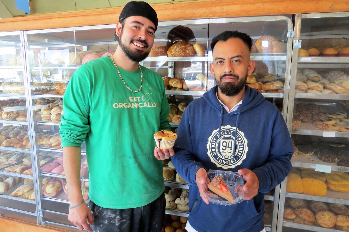 Camila's Bakery's head baker Bryan Hernandez, left, and owner Alejandro Diaz show off some of their new bakery items: gluten-free vegan muffins and chocolate cheesecake.