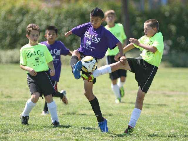 Whittier's Oscar Davila, middle, battles with two Mariners defenders as he tries to control the dribble during championship boys' 5-6 championship gold game Sunday.