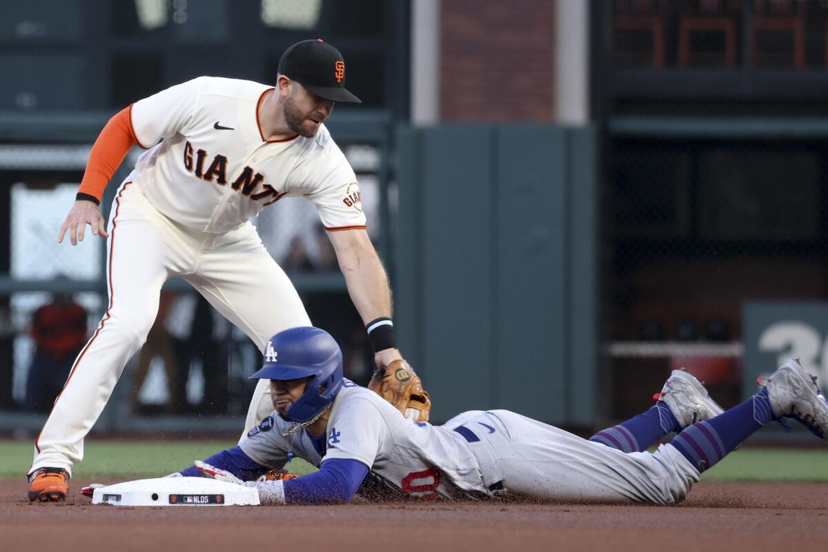 Dodgers baserunner Mookie Betts, bottom, beats the tag of Giants third baseman Evan Longoria to steal second base