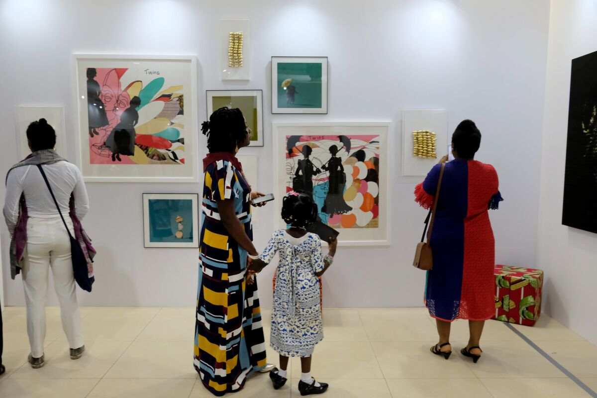 Visitors look at works on display at Art X Lagos, an international art fair that took over the Lagos Civic Center in November 2017.