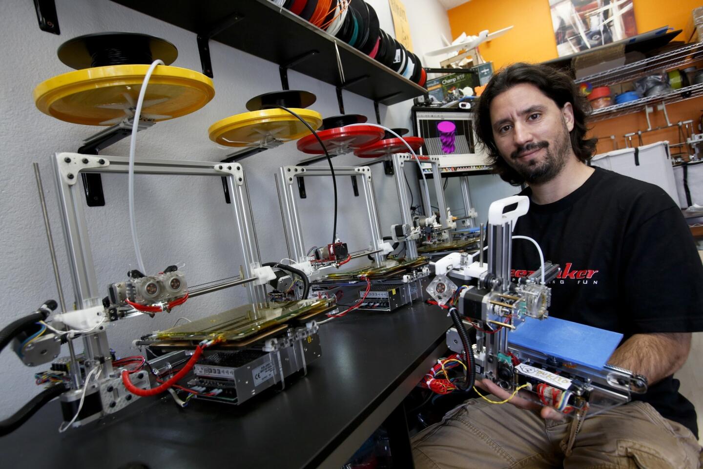 Diego Porqueras, owner of the Deezmaker store in Pasadena, holds a portable 3-D printer that he sells for $650.