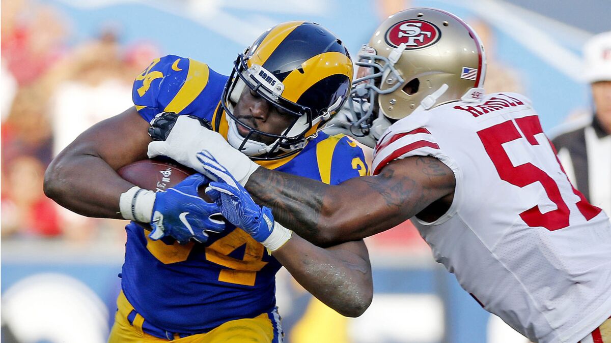 Rams running back Malcolm Brown is tackled by 49ers outside linebacker Eli Harold in the second half on Dec. 31, 2017.