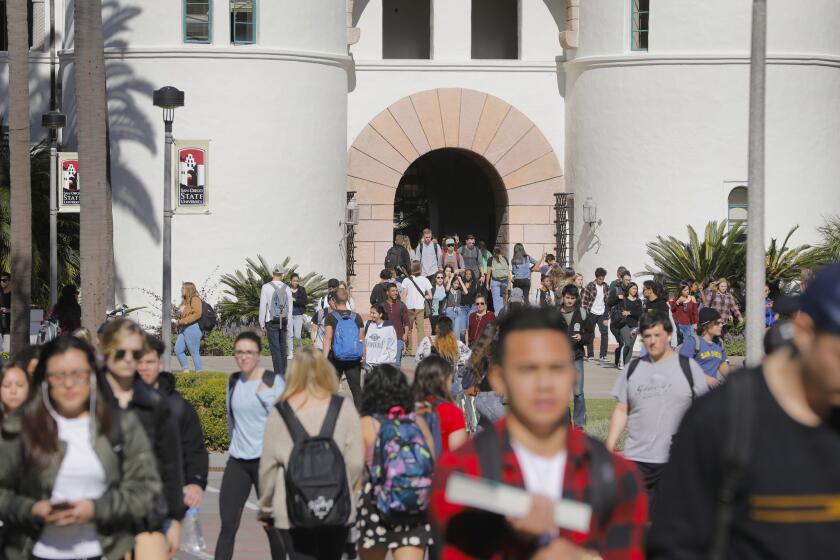 Students leave Hepner Hall and other buildings on the campus of San Diego State University, flowing onto the Campanile Walkway.
