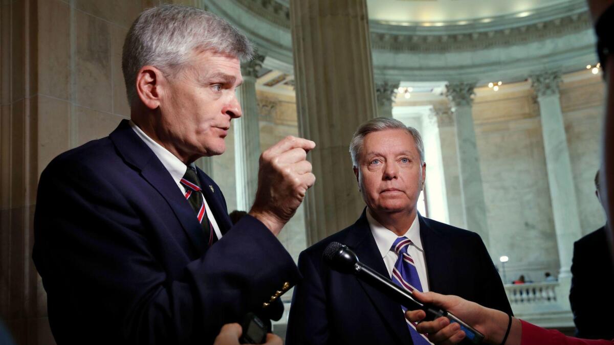 Sen. Bill Cassidy, left, and Sen. Lindsey Graham talk about health care on Capitol Hill in July.