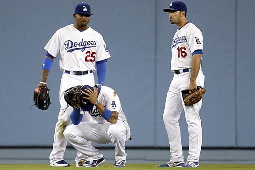 Dodgers center fielder Matt Kemp, flanked by left fielder Carl Crawford (25) and right fielder Andre Ethier (16) reacts to a misplayed ball earlier this season.