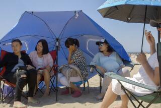 Chinese birth tourists gather in the shade during a day trip to the beach. Courtesy Leslie Tai