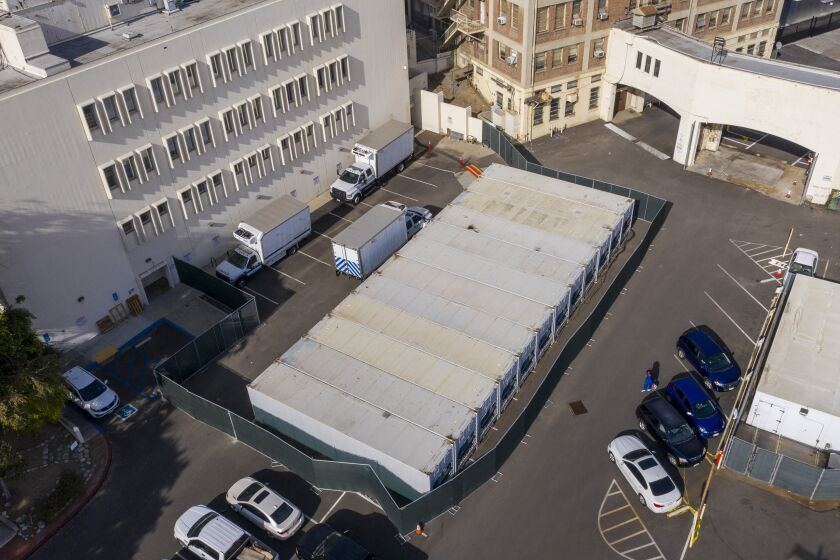 LOS ANGELES, CA - JANUARY 07: A dozen refrigerated storage containers hum in the parking lot at the Los Angeles County Coroner complex on Thursday, Jan. 7, 2021 in Los Angeles, CA. (Brian van der Brug / Los Angeles Times)
