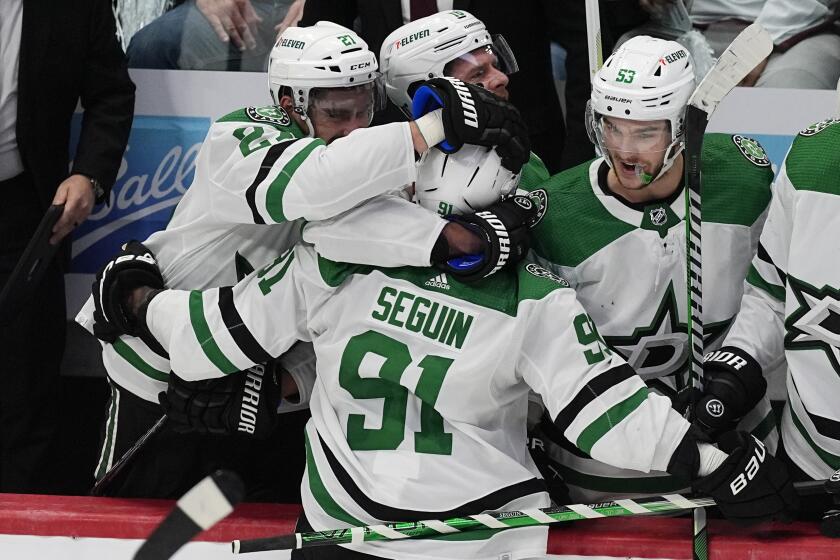 Dallas Stars center Tyler Seguin, front, is congratulated after scoring an empty-net goal against the Colorado Avalanche during the third period of Game 3 of an NHL hockey Stanley Cup playoff series Saturday, May 11, 2024, in Denver. (AP Photo/David Zalubowski)