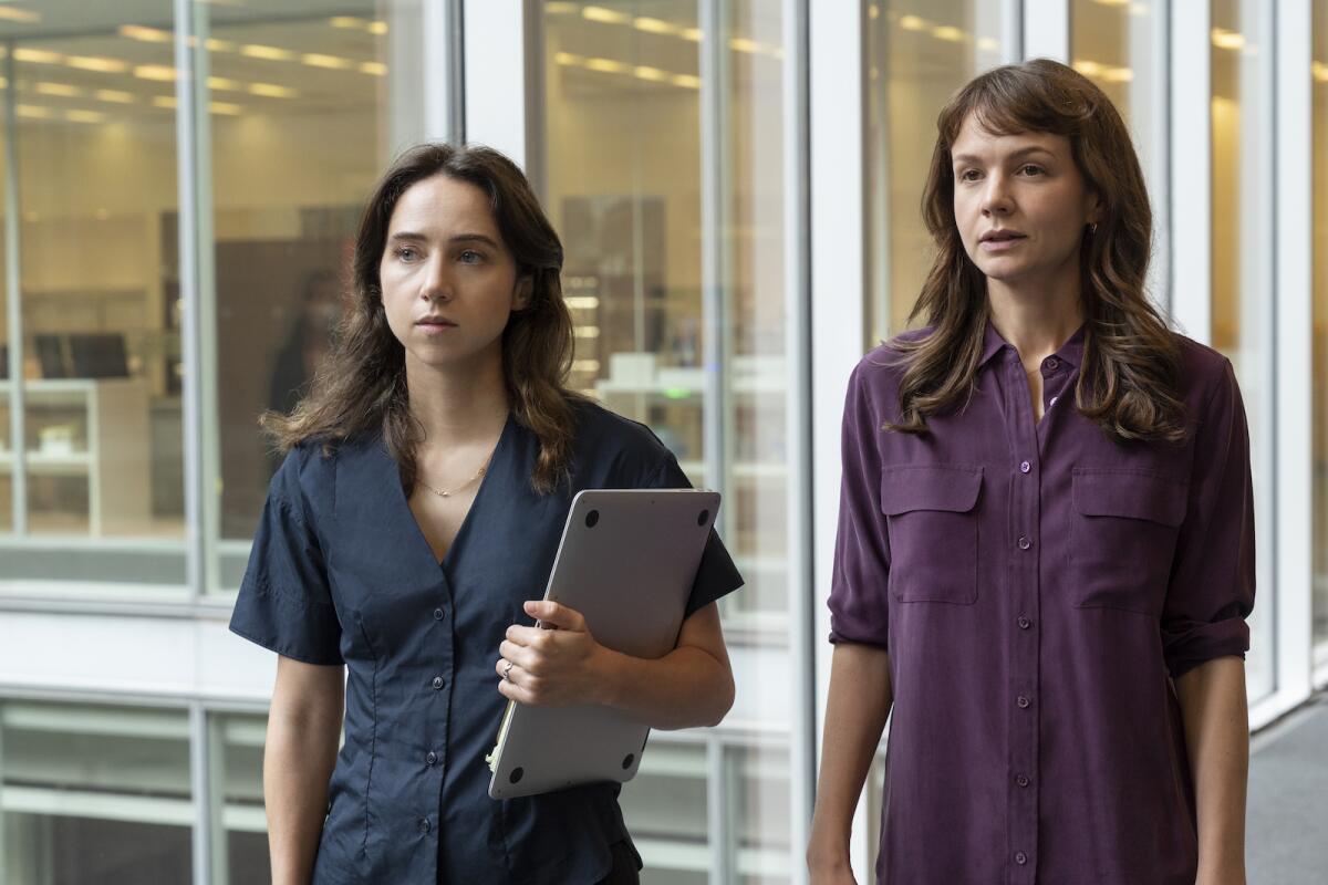 Two young women, one holding a lap top, in the movie "She Said."