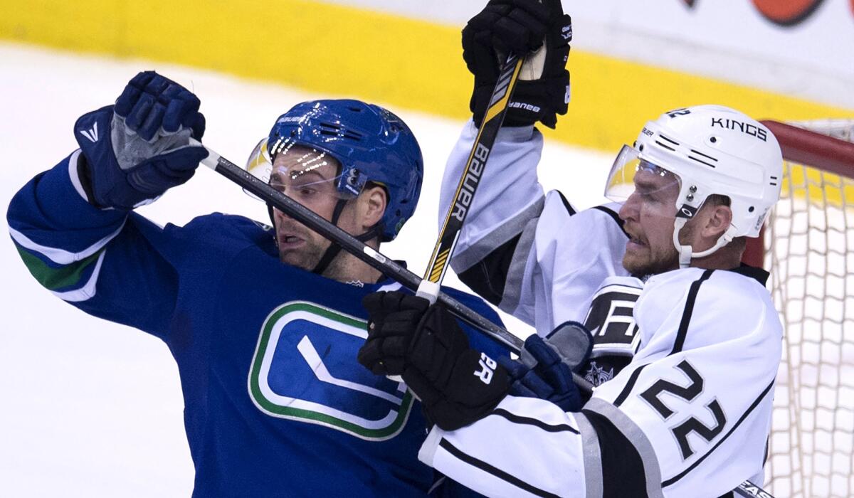 Kings center Trevor Liews (22) and Canucks defenseman Dan Hamhuis battle for position during a game on March 12 in Vancouver.
