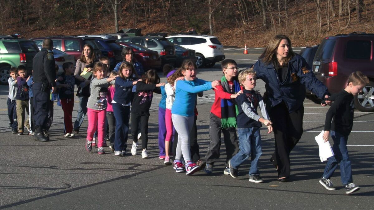 Police lead children from Sandy Hook Elementary School in Newtown, Conn., after the shooting there on Dec. 14, 2012.