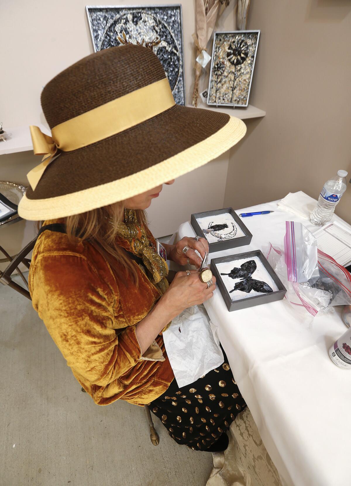 Mosaic artist Victoria Foley works on a butterfly piece during opening day at Art-A-Fair on June 30.