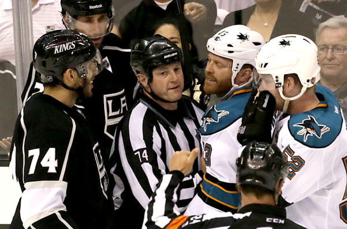 Kings forward Dwight King (74) takes exception with Sharks center Raffi Torres, who is held back by rferee Lonnie Cameron after Torres was called for an illegal hit on Jarret Stoll in the second period of Game 1 on Tuesday night at Staples Center.