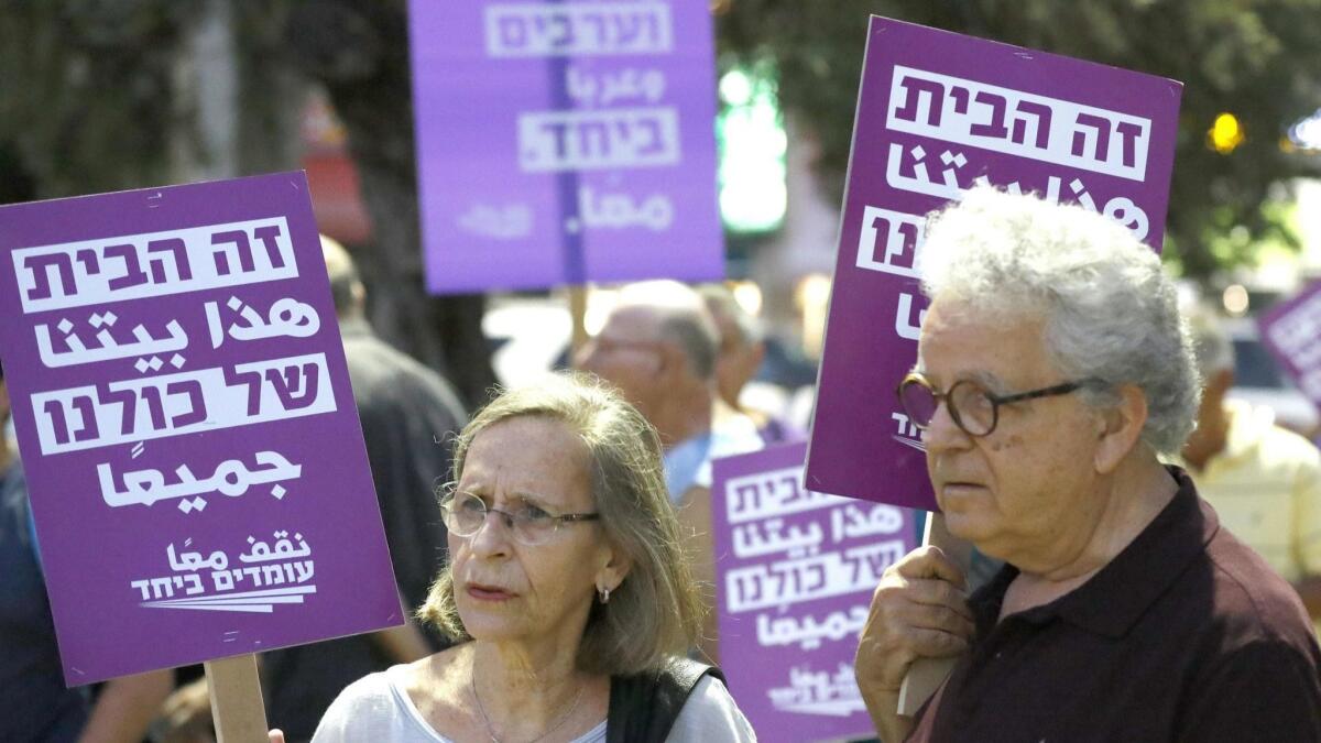 Demonstrators attend a rally to protest the Jewish nation-state bill in Tel Aviv on July 14, 2018.