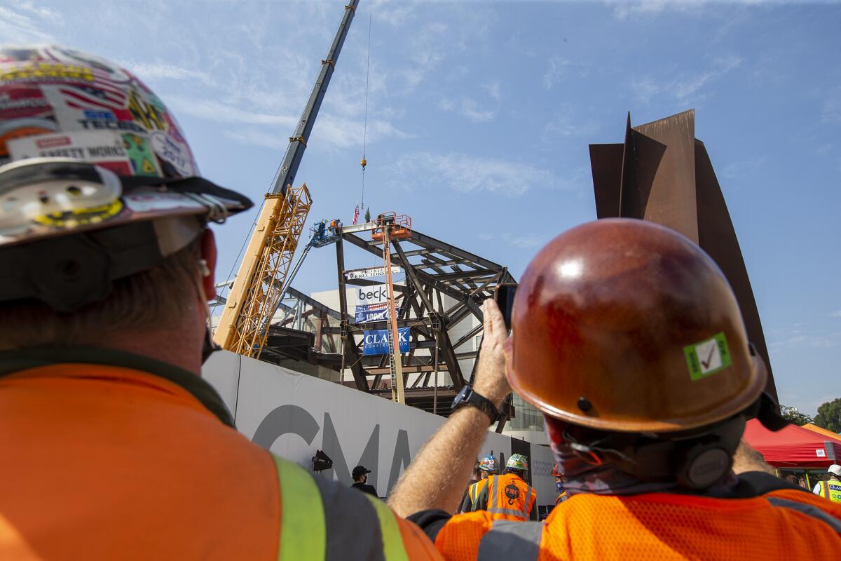 Soren Stufkosky, left, and Brad McGlothlin watch at the site of the new Orange County Museum of Art on Tuesday.