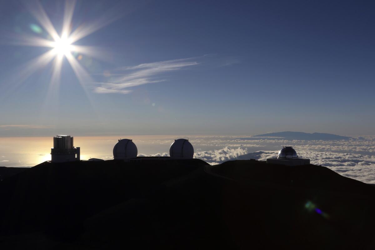 FILE - The sun sets behind telescopes on July 14, 2019, at the summit of the Big Island's Mauna Kea in Hawaii. For over 50 years, telescopes have dominated the summit of Mauna Kea, a place sacred to Native Hawaiians and one of the best places in the world to study the night sky. That's now changing with a new state law saying Mauna Kea must be protected for future generations and that science must be balanced with culture and the environment. (AP Photo/Caleb Jones, File)