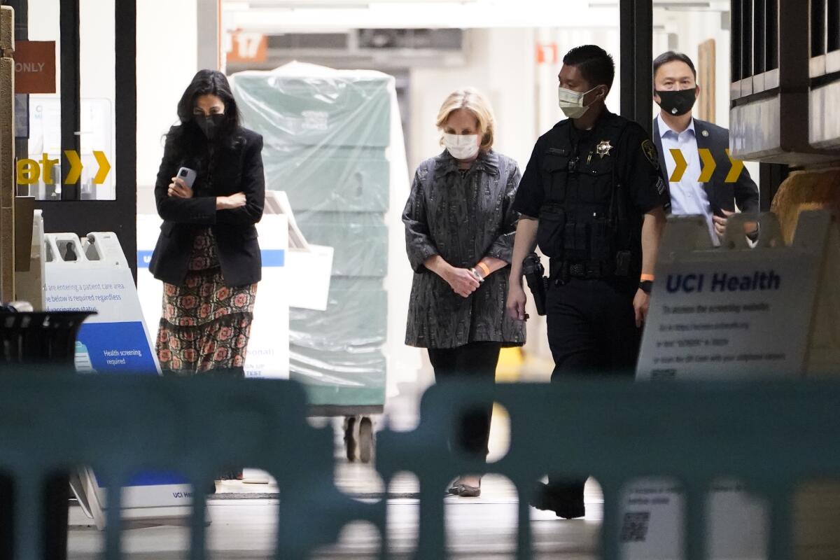 Former Secretary of State Hillary Clinton, center, is leaving UC Irvine Medical Center.