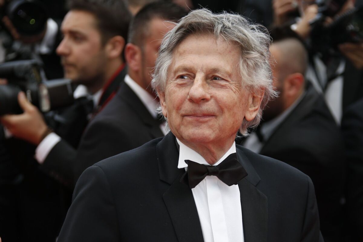 Roman Polanski poses for photos as he arrives for the screening of the film "Saint-Laurent" at the 67th edition of the Cannes Film Festival on May, 17, 2014.