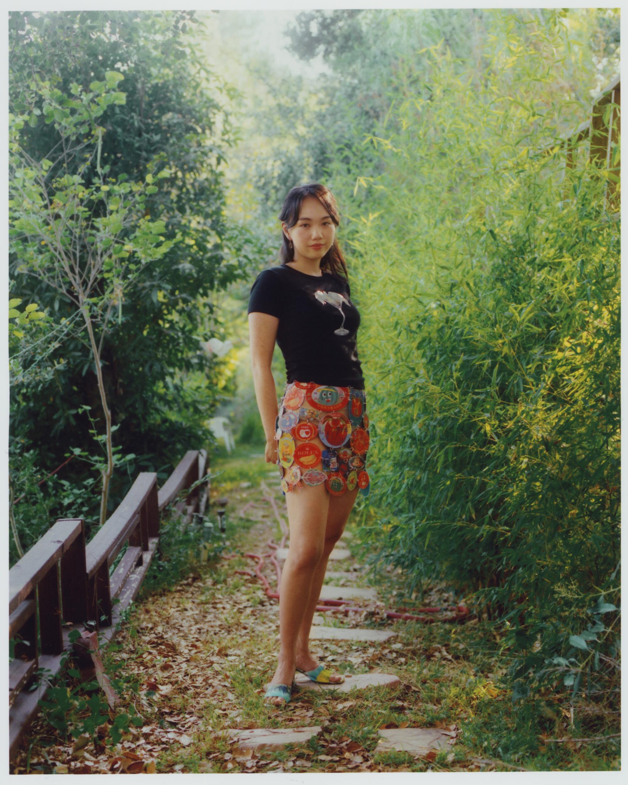 Leeann wears Leeann Huang Shrimp Cocktail Baby Tee, Fruit Sticker Chain Link Skirt, and Landscape Strappy Mules