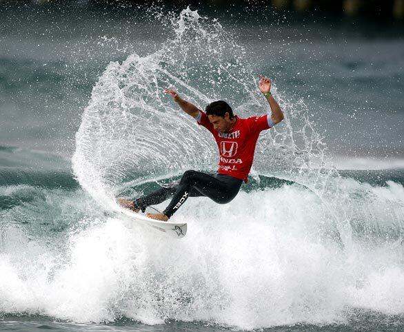 Nathaniel Curran of Oxnard cuts back across the lip of a wave during a semifinal run against Gabe Kling on Sunday in the U.S. Open of Surfing in Huntington Beach. Curran would defeat Tim Boal of France in the finals to win the event.