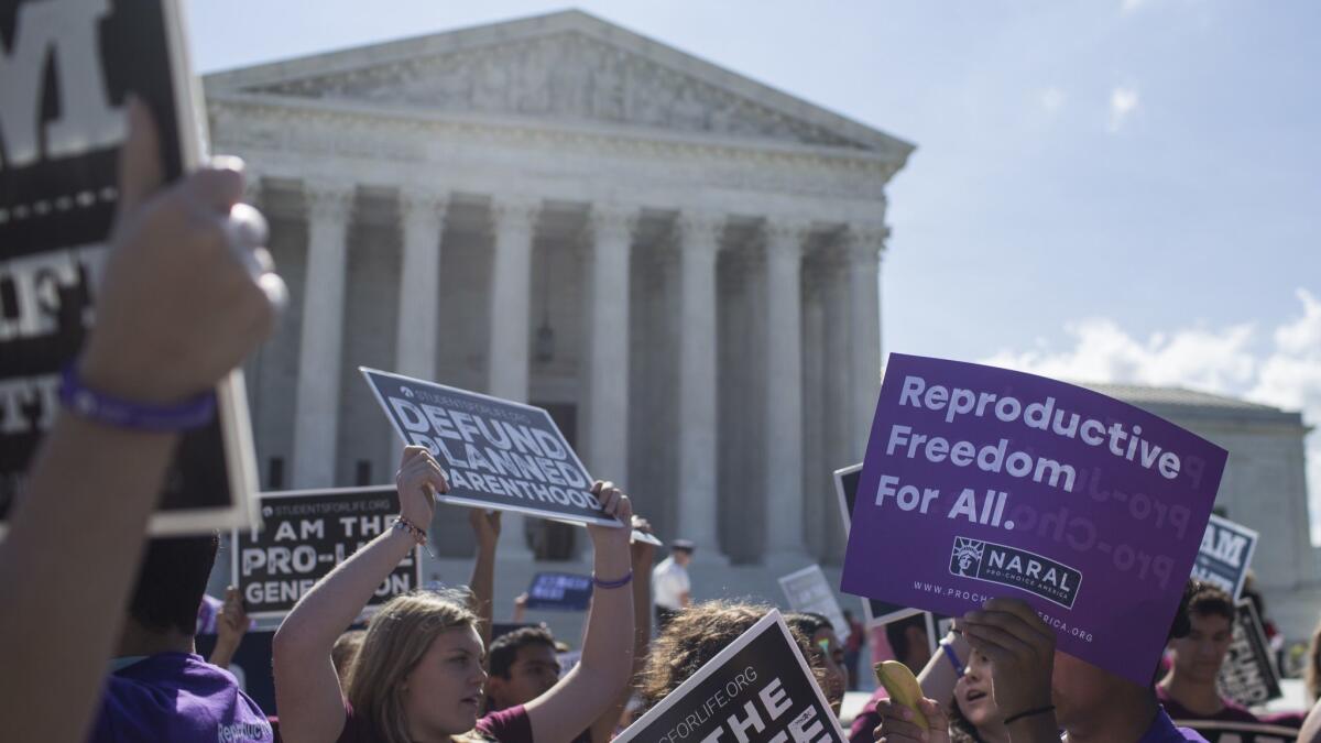 Abortion rights opponents and supporters demonstrate outside the U.S. Supreme Court on Monday. With the retirement of Justice Anthony M. Kennedy, the court could move to overturn Roe vs. Wade.