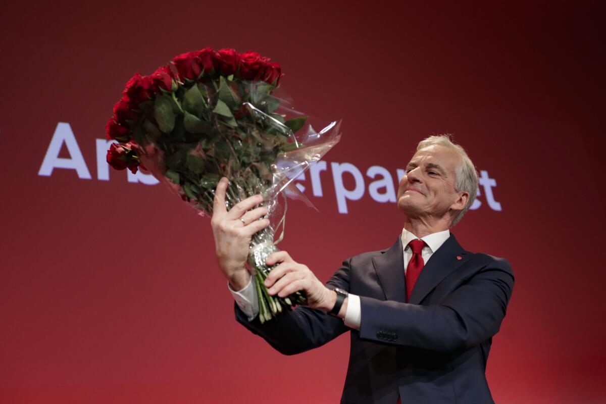 CORRECTS BYLINE TO JAVAD PARSA, NOT HEIKO JUNGE - Labor leader Jonas Gahr Stoere holds a bouquet of red roses at the Labor Party's election vigil for the 2021 parliamentary elections at the People's House in Oslo, Norway on Monday, Sept. 13, 2021. The center-left bloc headed to a victory in Norway's elections Monday as official projections pointed to the governing Conservatives losing power after a campaign dominated by climate change and the future of the country’s oil and gas exploration industry. (Javad Parsa/NTB via AP)