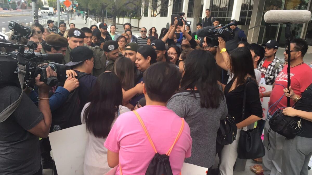 Manifestantes en el centro de Los Ángeles forman un anillo protector sobre Claudia Rueda, la hija de Teresa Vidal-Jaime, quien fue detenida durante una redada realizada el lunes en Boyle Heights. La inmigrante ahora enfrenta deportación. (Richard Winton / Los Angeles Times)