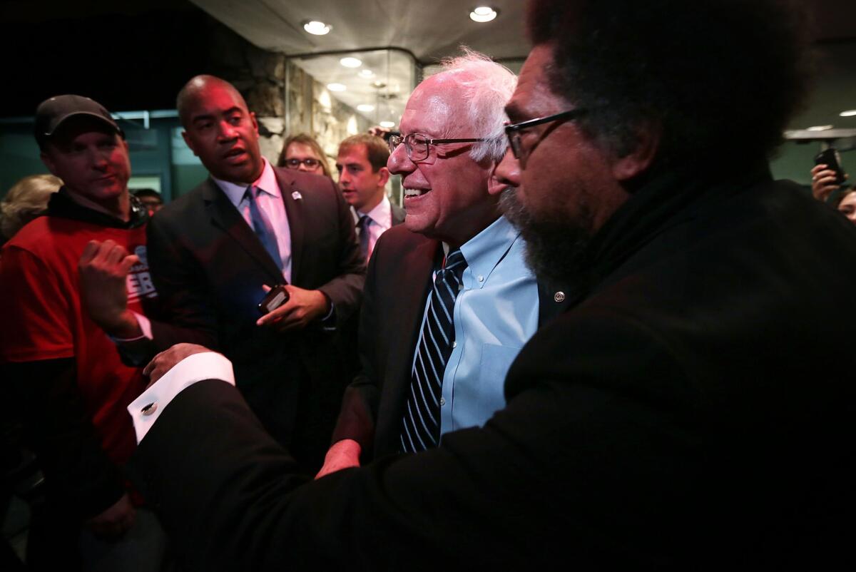 Cornel West, right, greets supporters with Democratic presidential candidate Sen. Bernie Sanders at a debate party last weekend in Des Moines. West has also spoken on Sanders' behalf at college rallies.