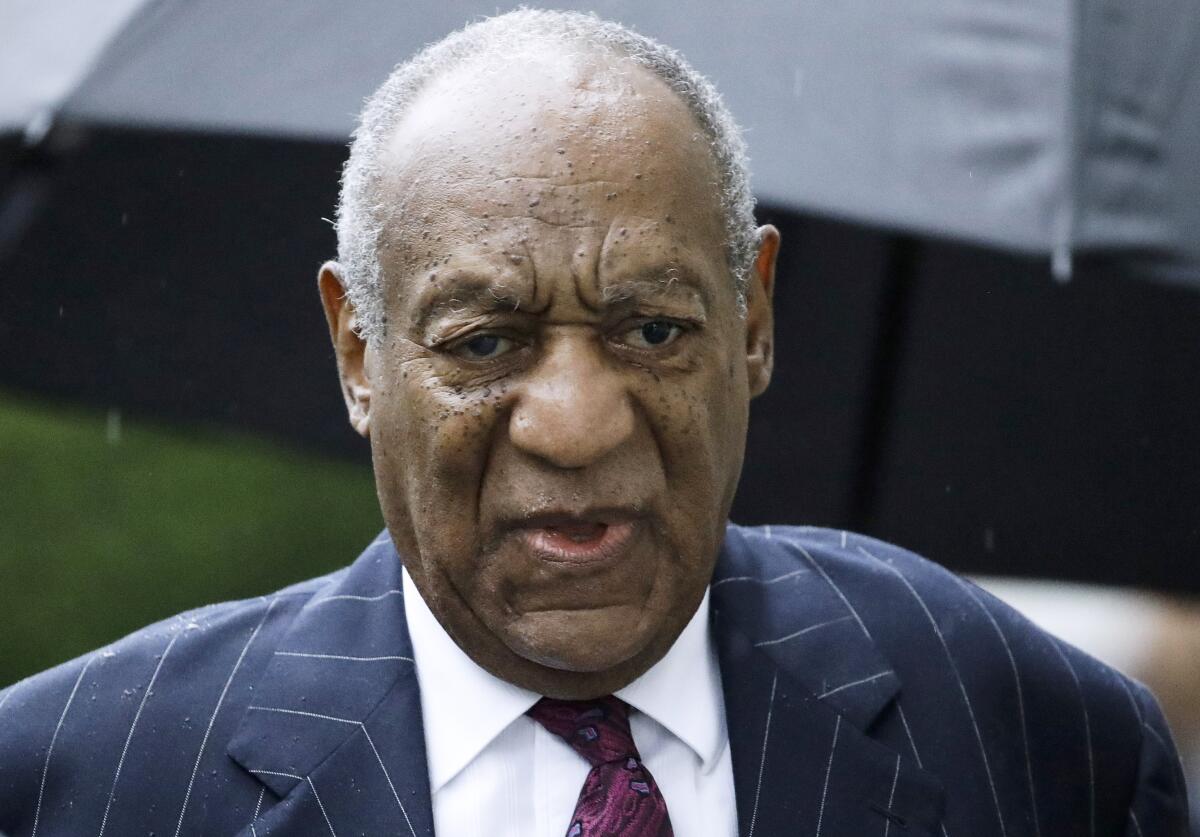 An older man in a suit and tie looks serious as he arrives at a courthouse