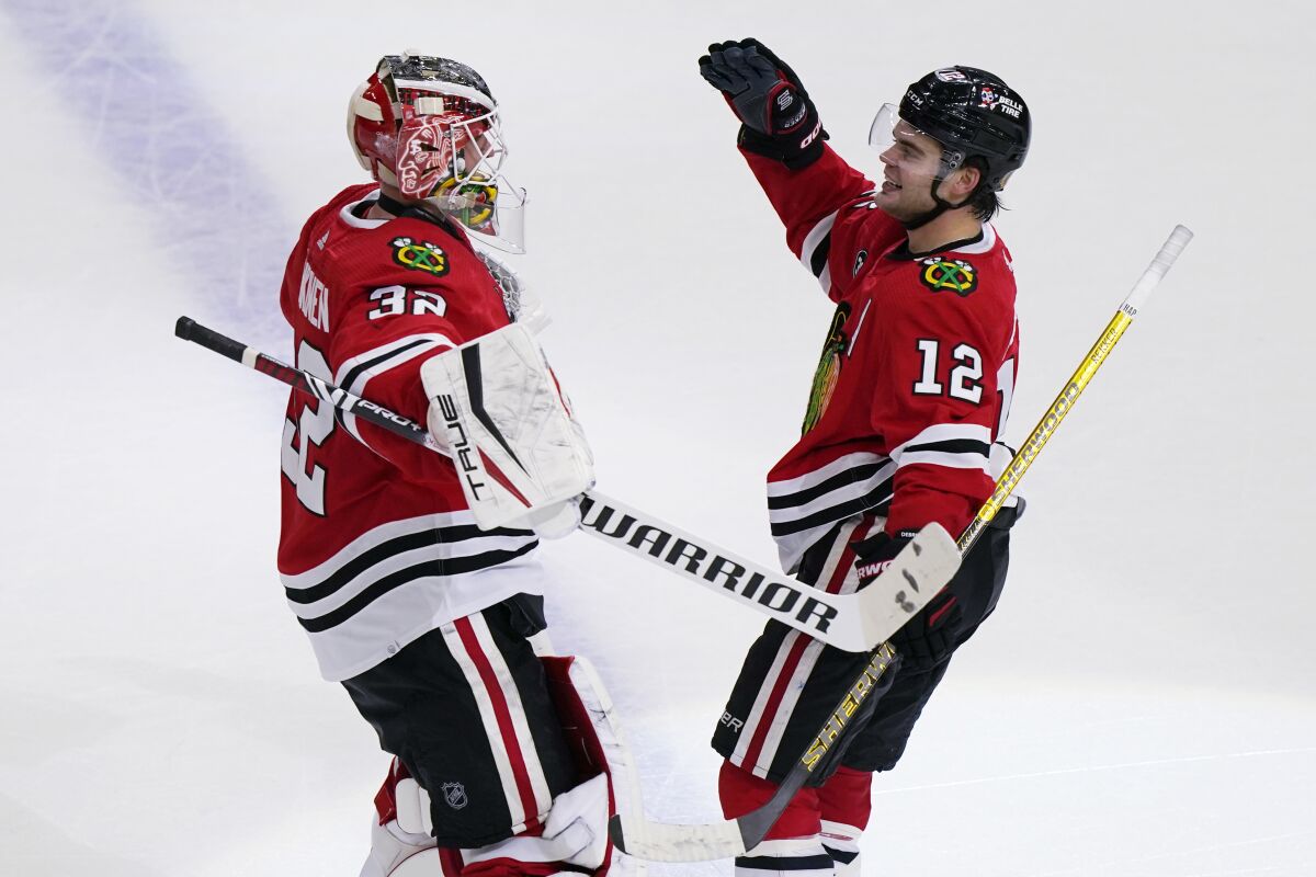 Chicago Blackhawks left wing Alex DeBrincat, right, celebrates with goaltender Kevin Lankinen after scoring the game-winning goal against the Nashville Predators during an overtime period of an NHL hockey game in Chicago, Sunday, Nov. 7, 2021. The Chicago Blackhawks won 2-1 in overtime. (AP Photo/Nam Y. Huh)