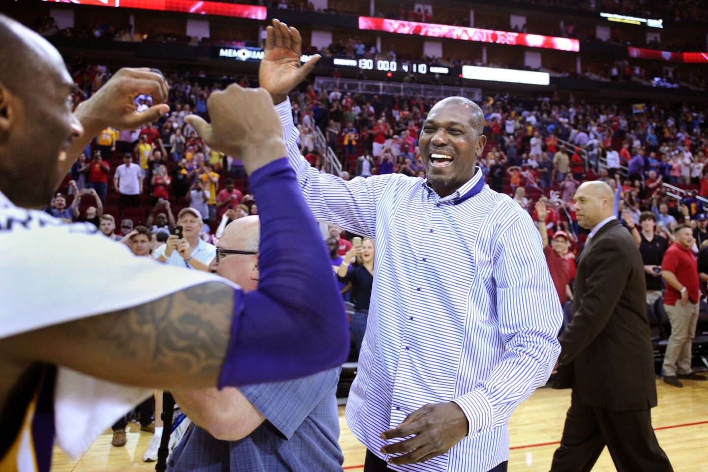 Former Rocket Hakeem Olajuwon and Lakers star Kobe Bryant greet each other after the game in Houston.